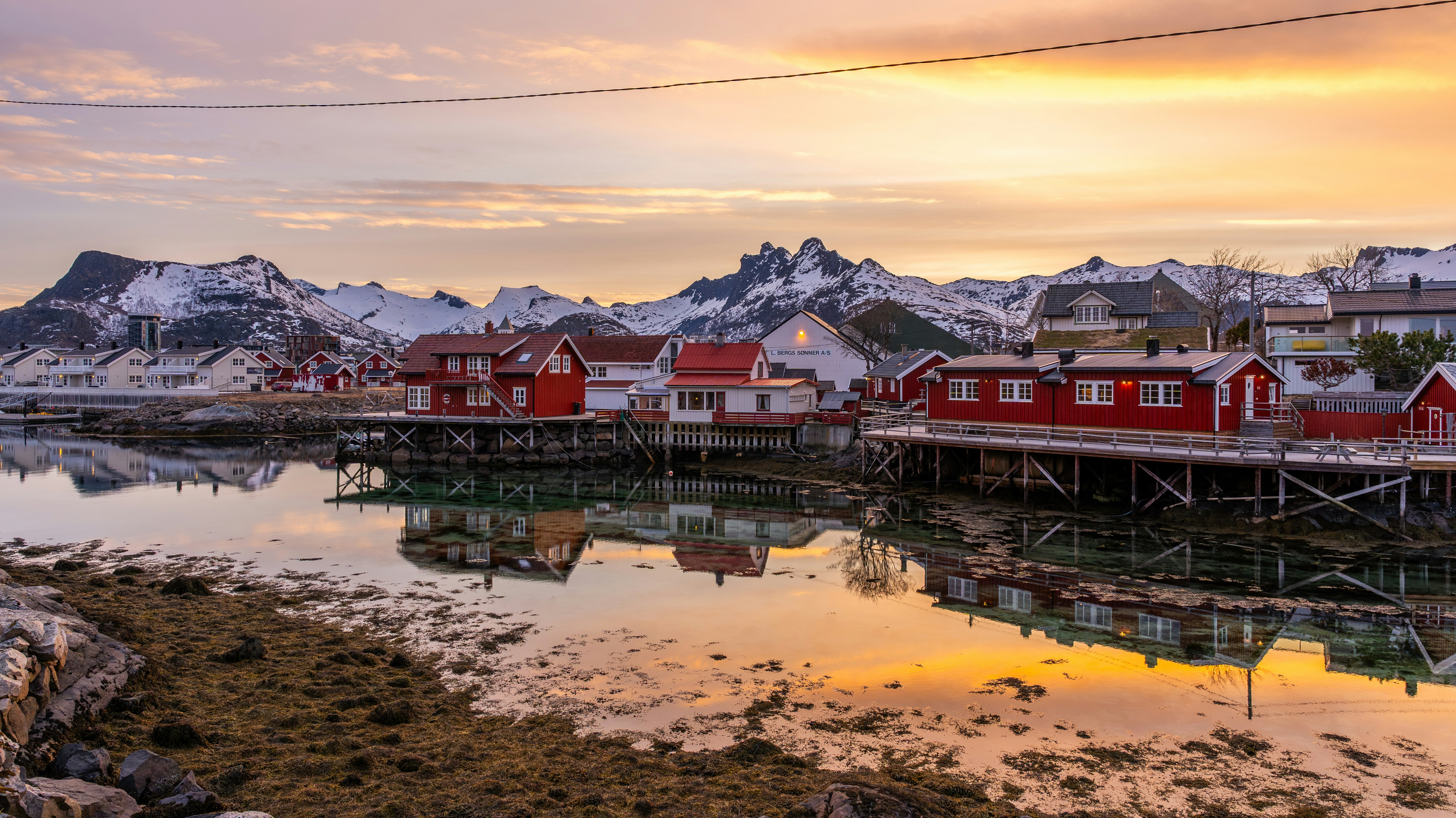 Eine Gruppe roter Häuser, die neben einem Gewässer sitzen