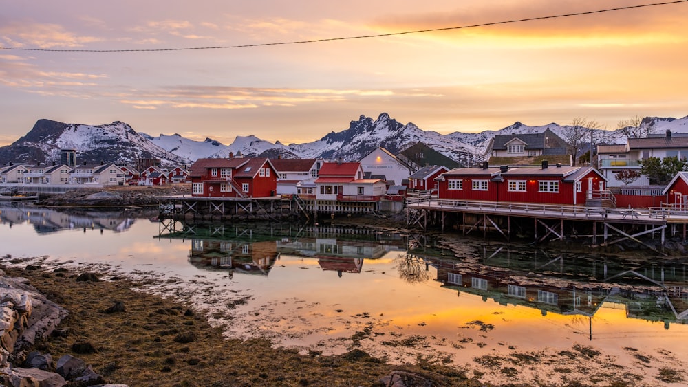 a group of red houses sitting next to a body of water