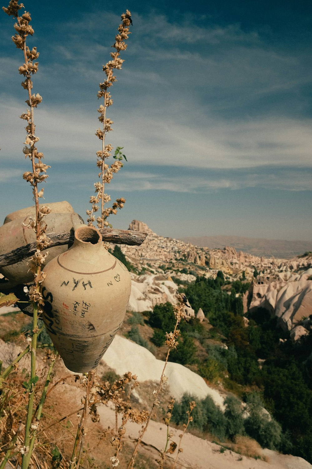 a vase with writing on it sitting on top of a hill