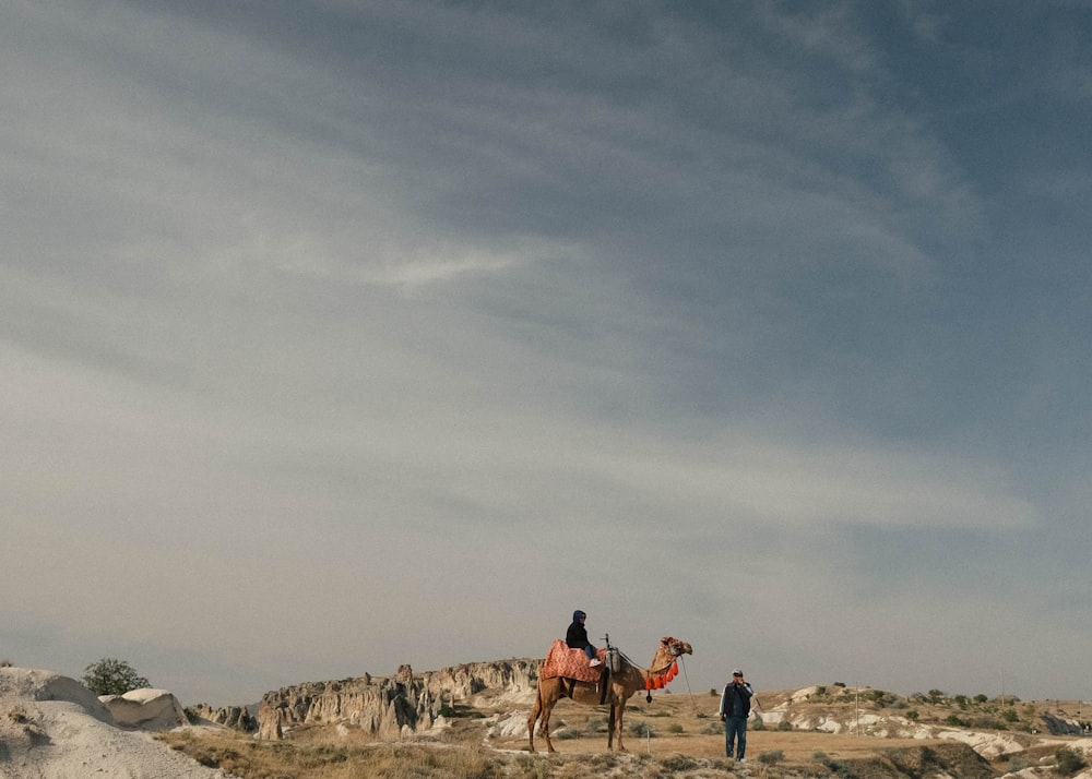 a couple of people that are standing next to a camel