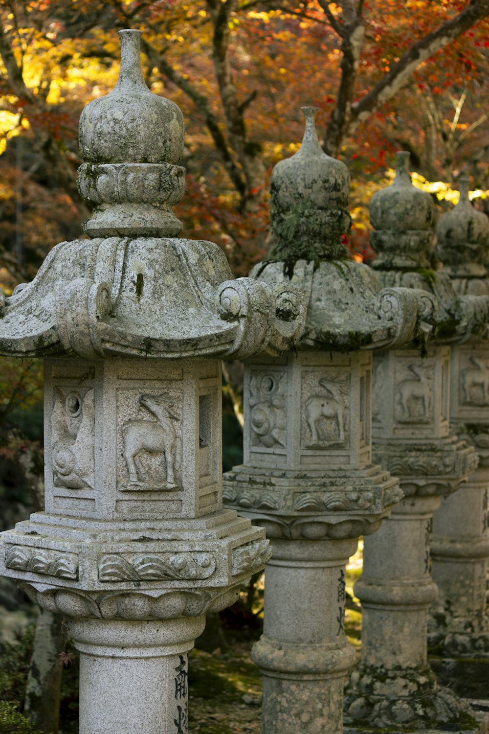 a row of stone pillars in front of a tree