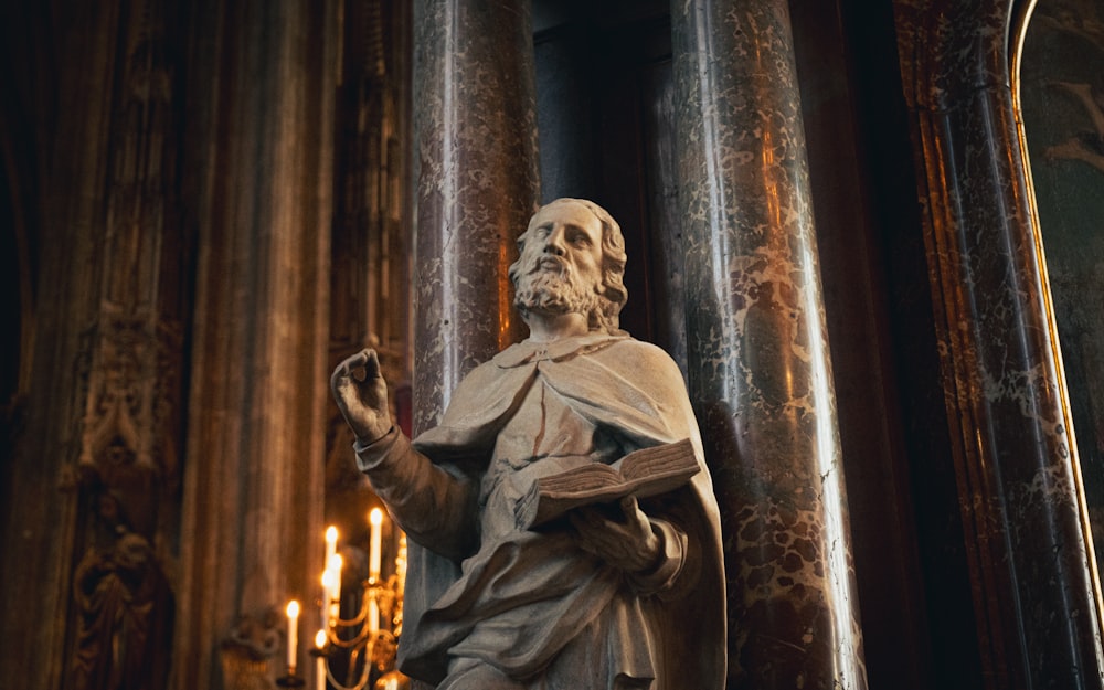 a statue of a man holding a book in a church