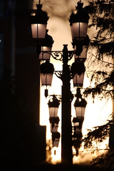 a street light with the sun setting in the background