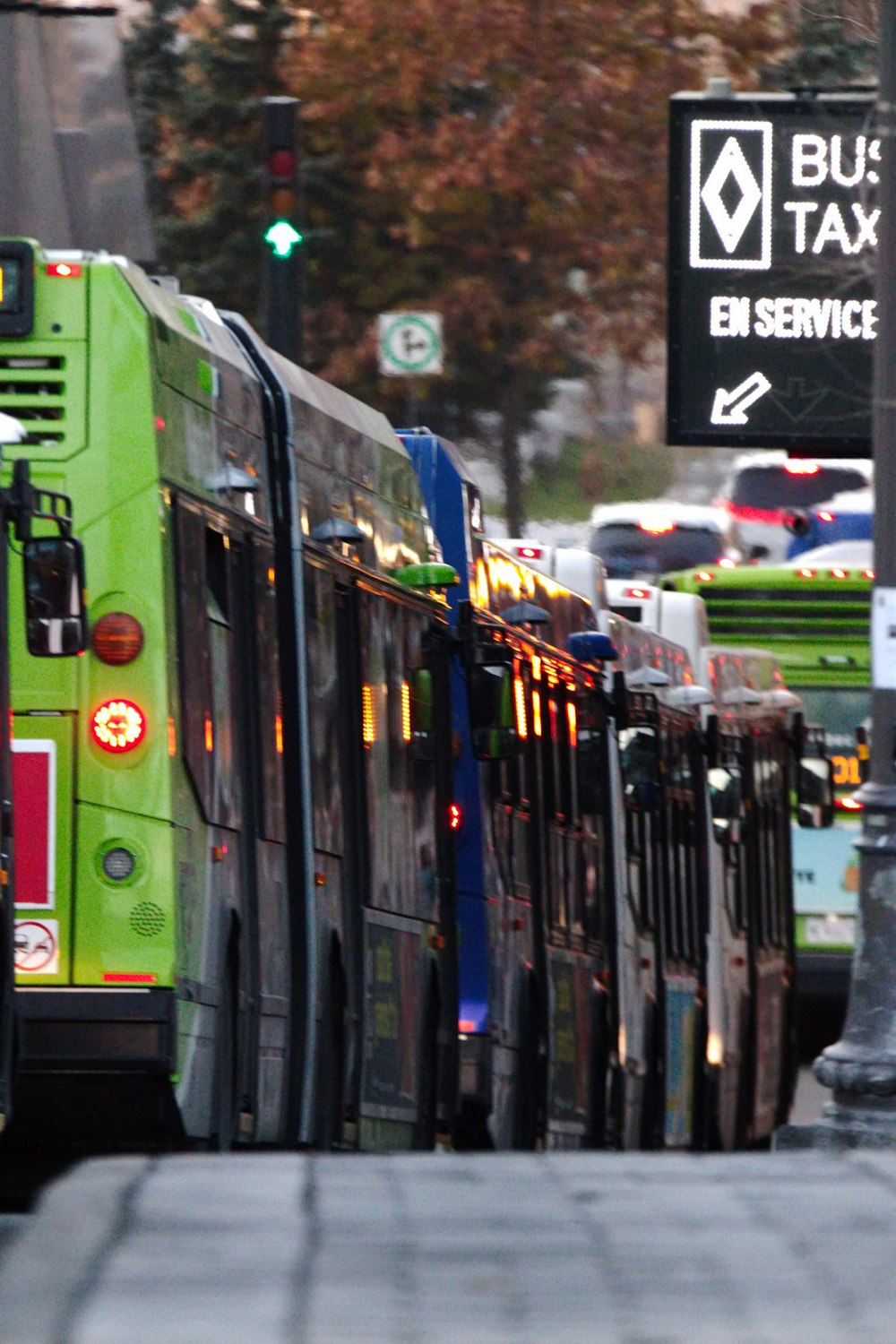 a green bus driving down a street next to a traffic light