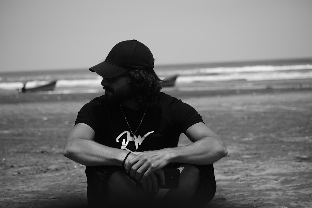 a man sitting on a beach next to the ocean