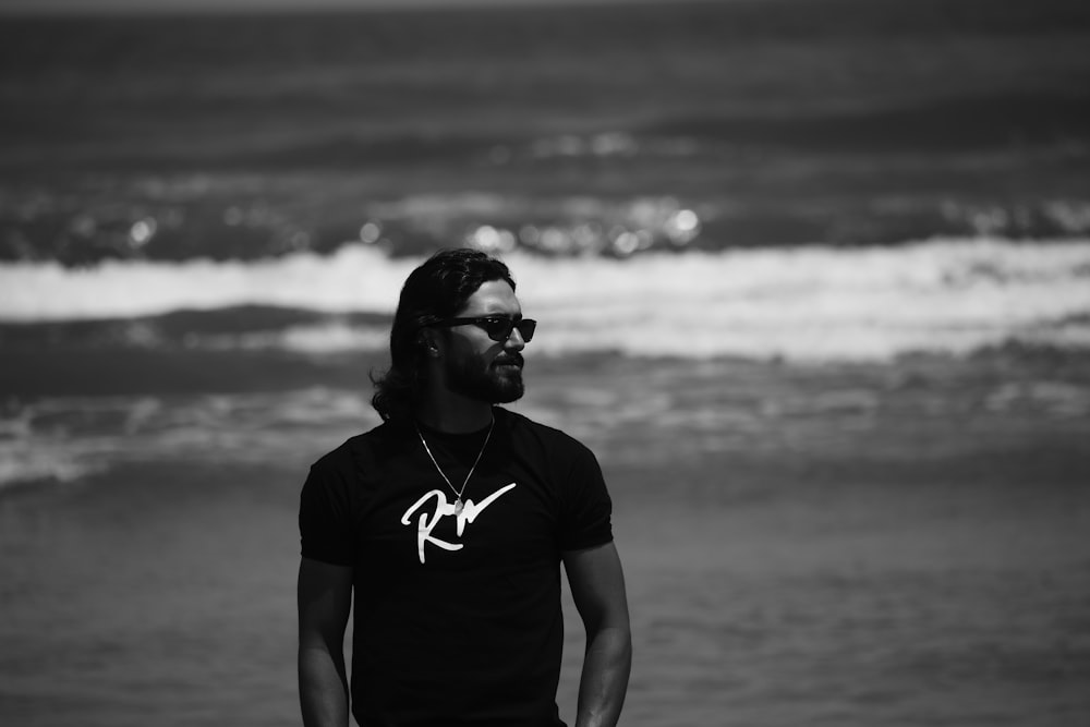 a man standing on a beach next to the ocean