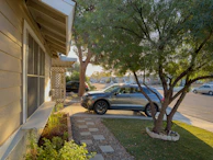 A family unloading luggage from a spacious SUV in a suburban driveway.