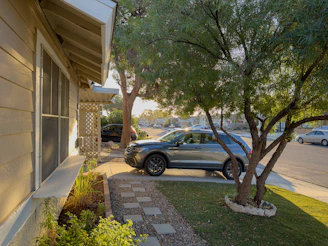 A family unloading luggage from a spacious SUV in a suburban driveway.