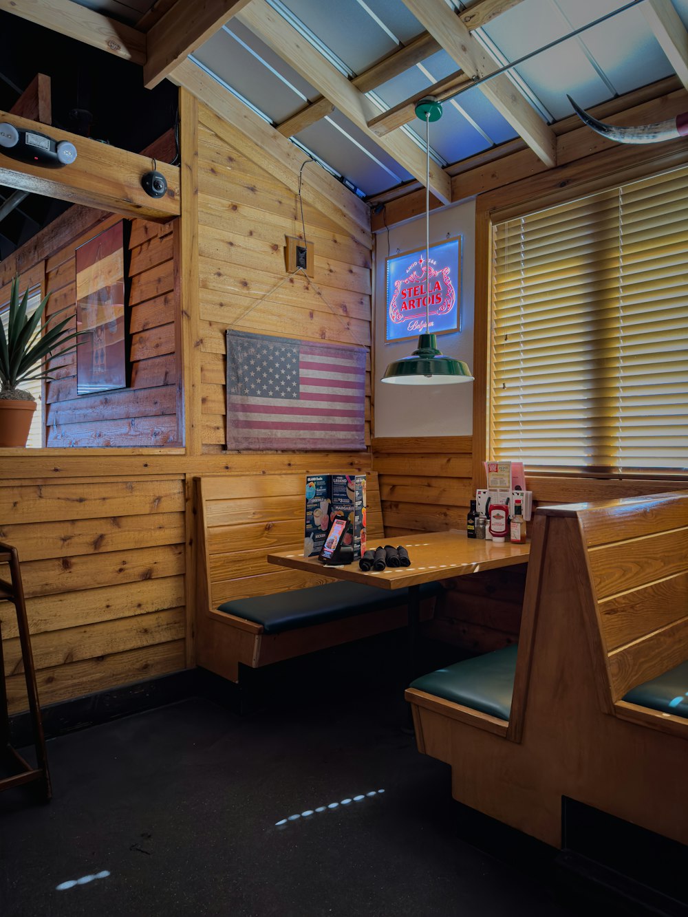 a restaurant with wooden booths and american flags on the wall
