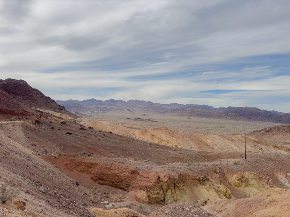 a view of a desert with mountains in the background