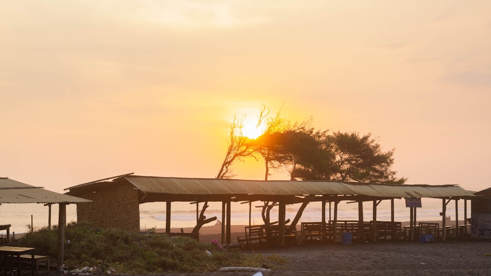 the sun is setting over the beach huts