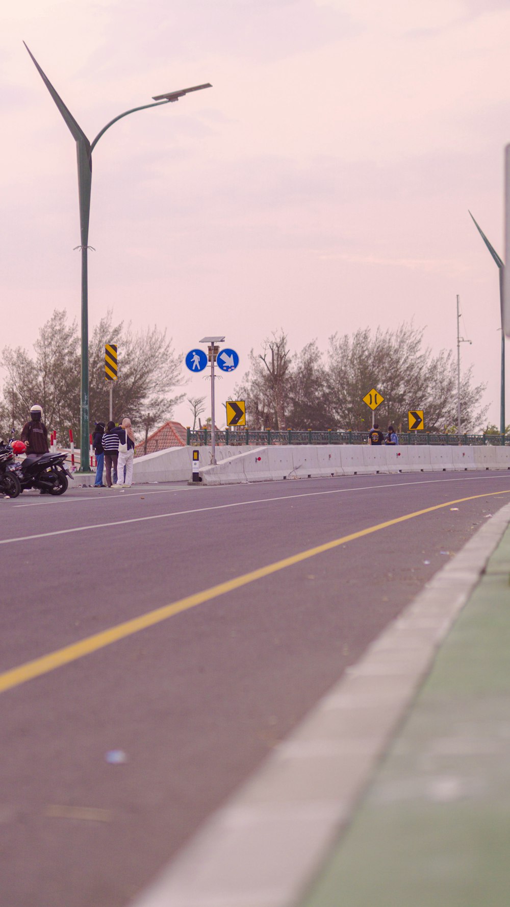 a motorcycle driving down a street next to a traffic light