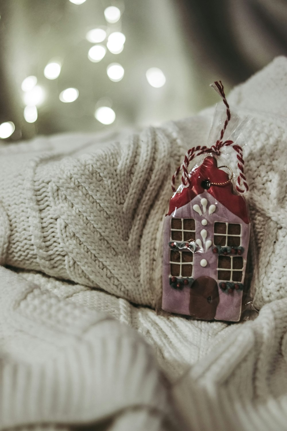 a house ornament hanging from a blanket