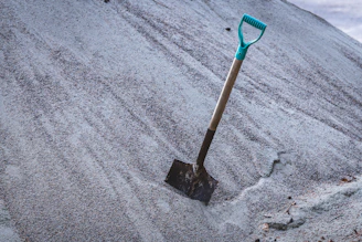 a shovel stuck in the sand on a hill