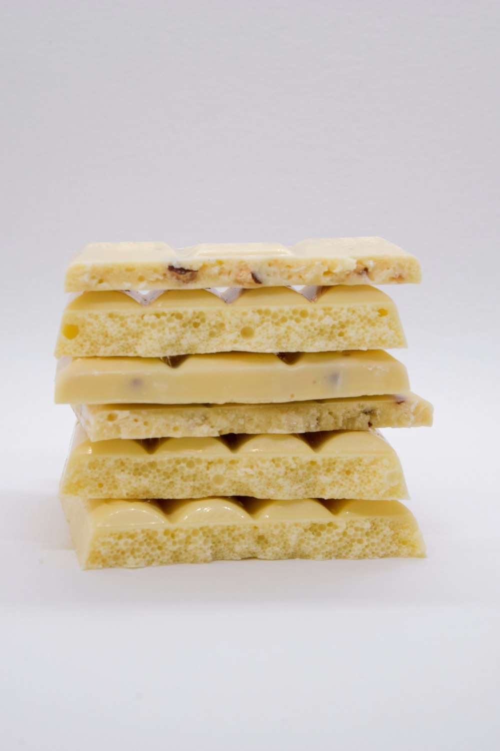 a stack of four pieces of food on a white surface