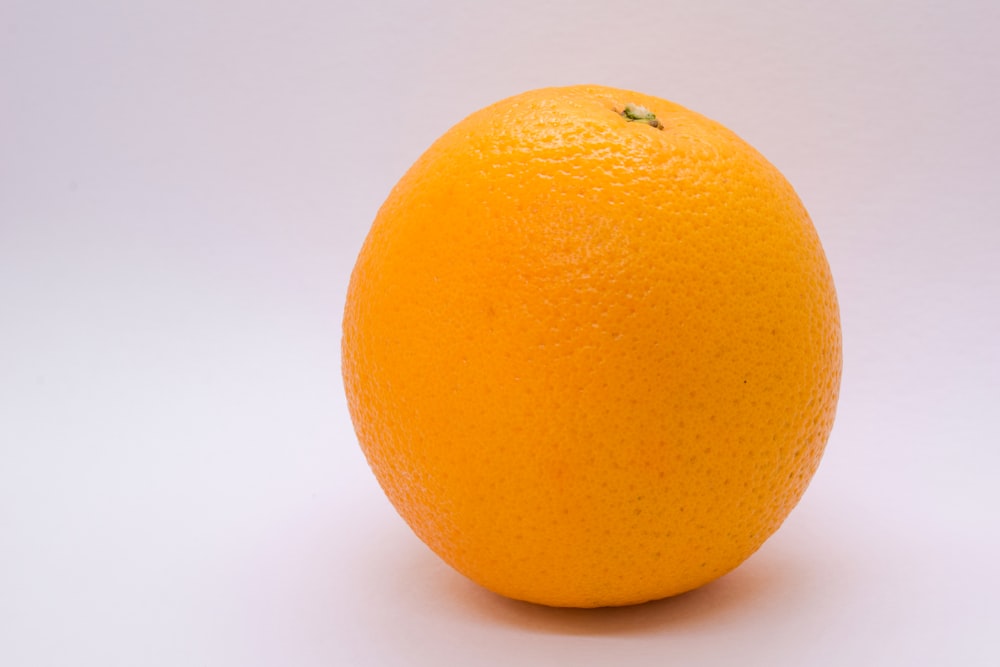 an orange sitting on top of a white table