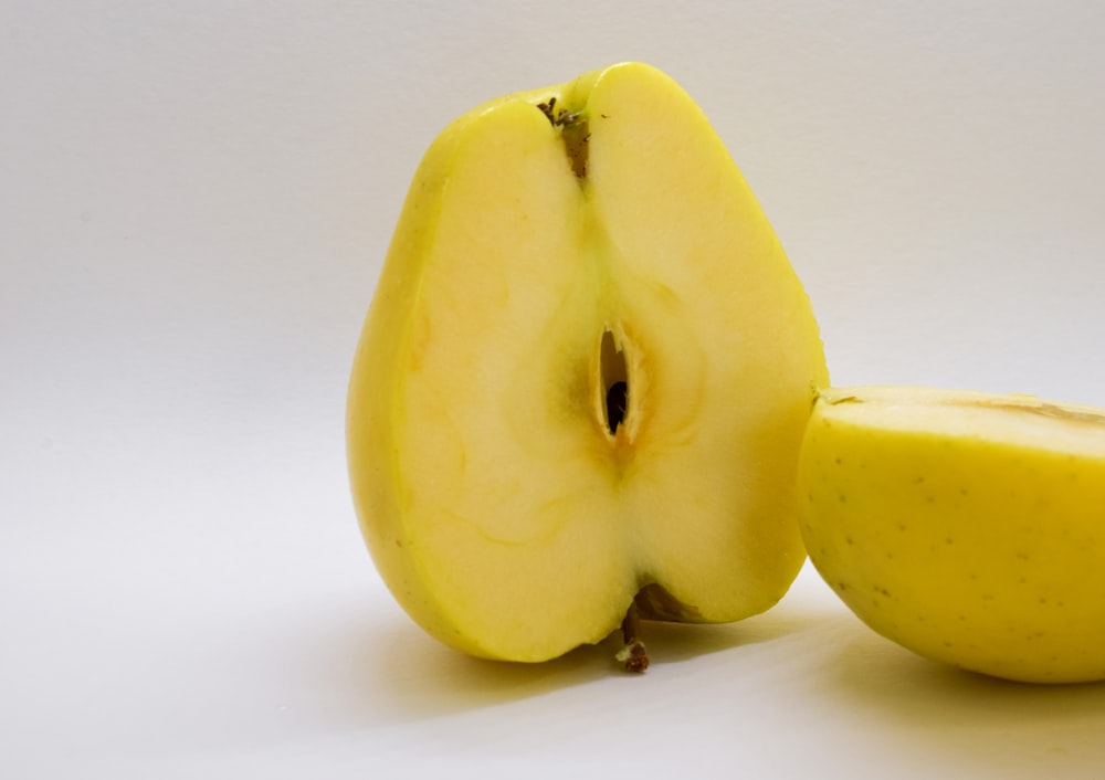 an apple cut in half with a white background