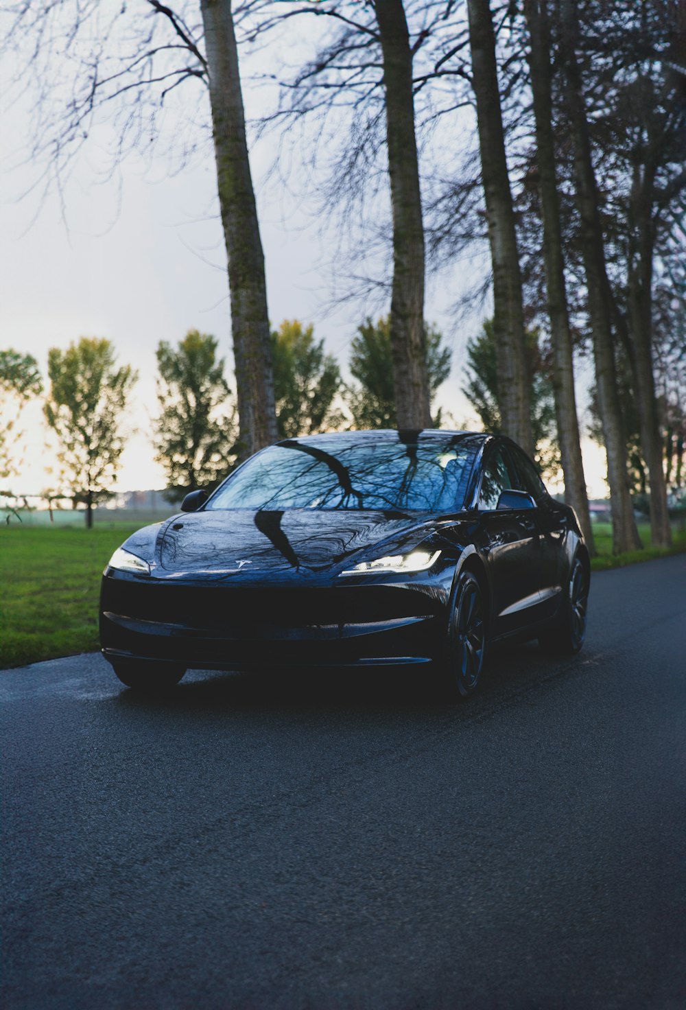 um carro esportivo preto estacionado na beira de uma estrada