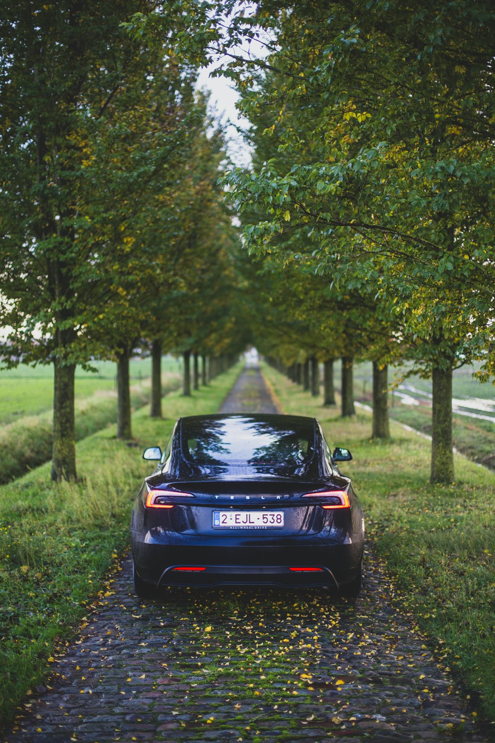 a blue car parked on the side of a road