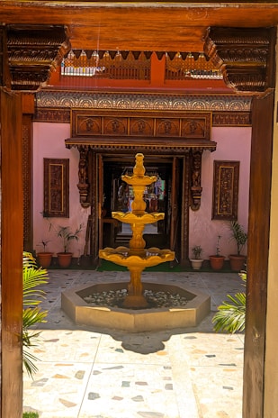 Beautifully crafted wooden doors opening to a serene garden area within the haveli.