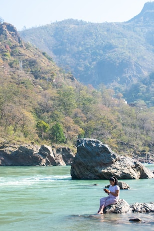 A serene landscape with a person relaxing while streaming videos on a tablet.