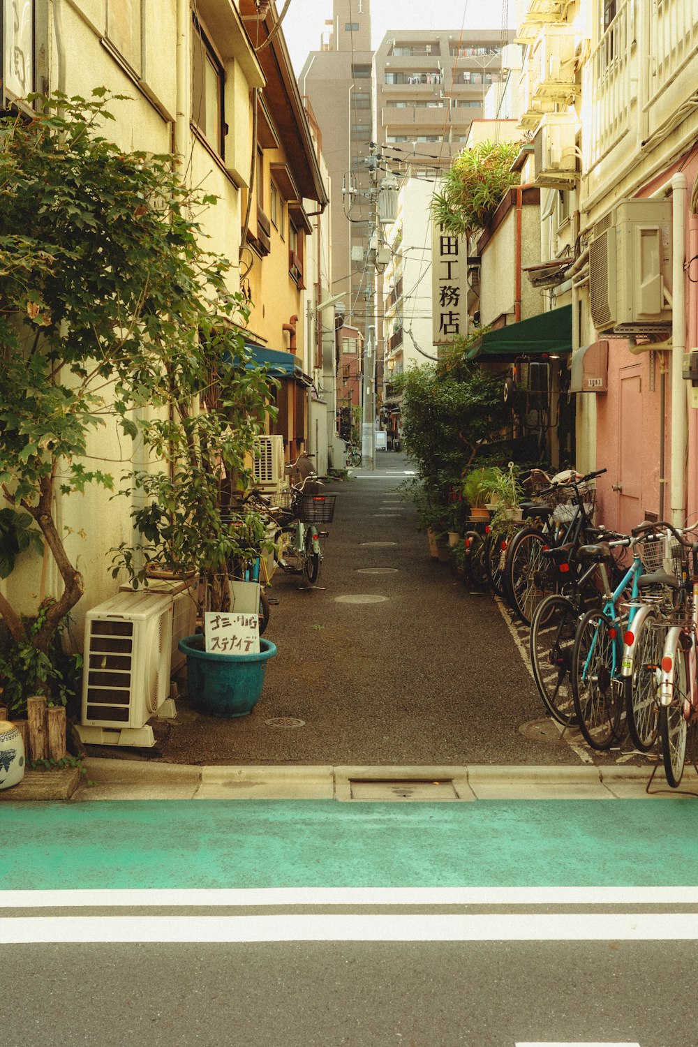 a narrow city street lined with parked bicycles
