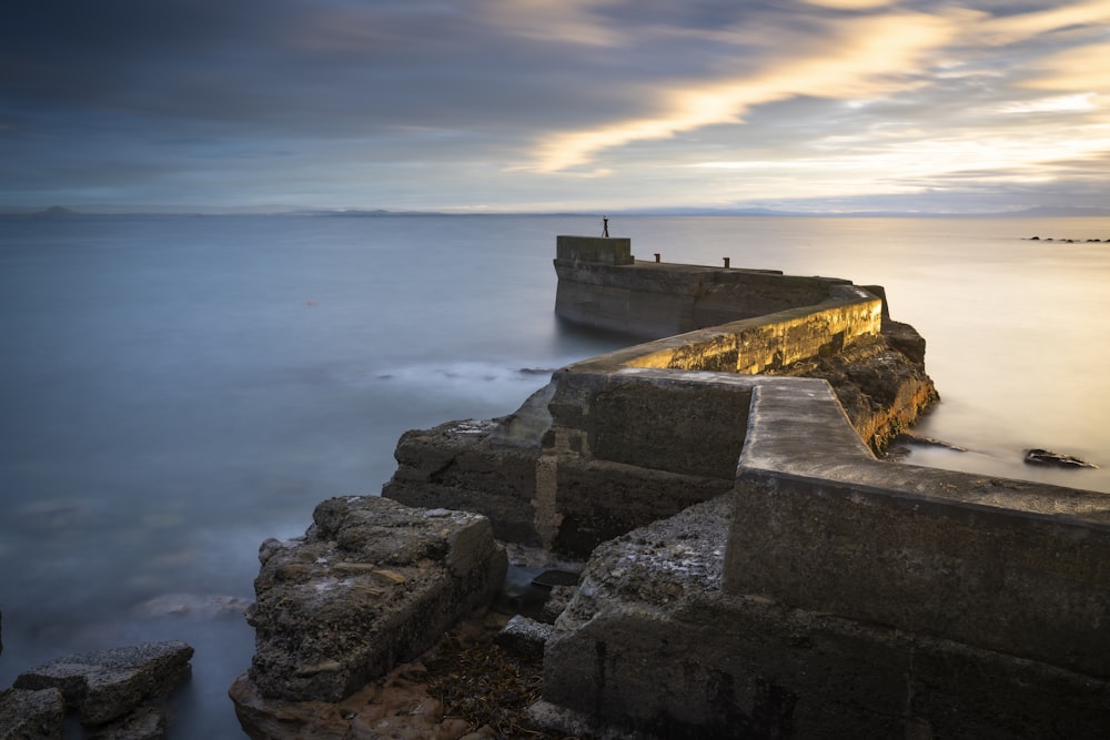 a long exposure photo of the ocean and a pier