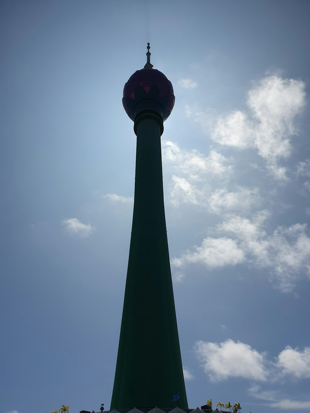 a tall green tower with a clock on top