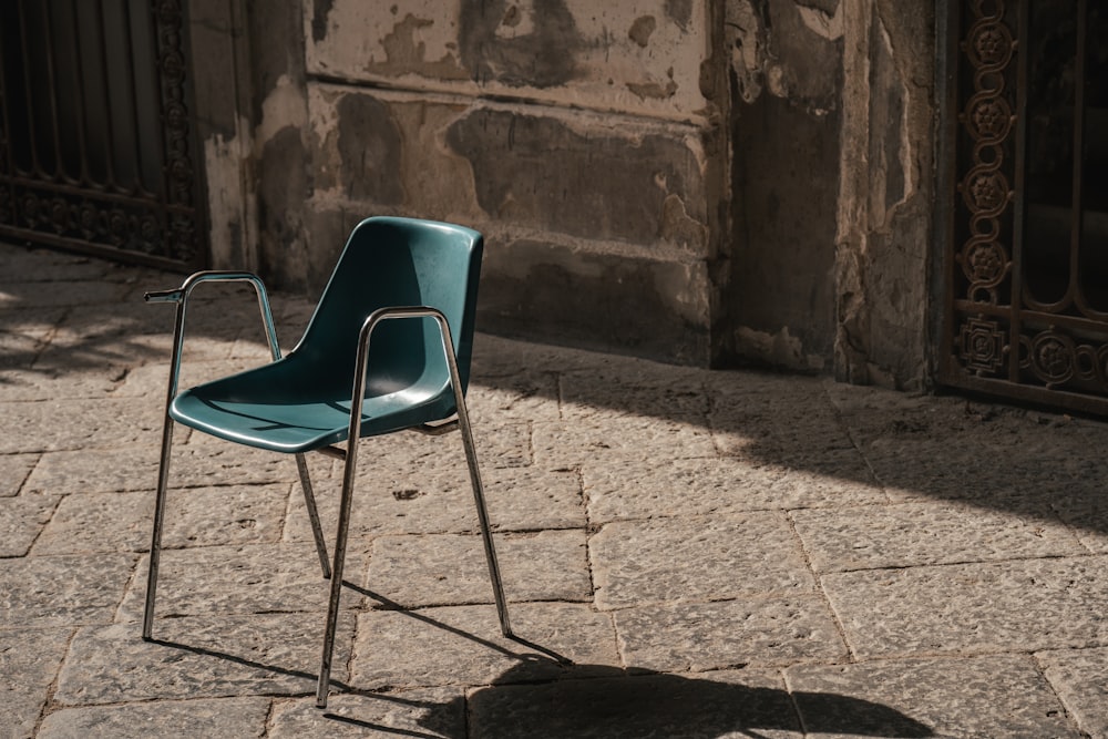 a blue chair sitting on top of a stone floor