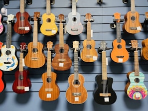 Brightly colored ukuleles hanging on a rustic wooden wall