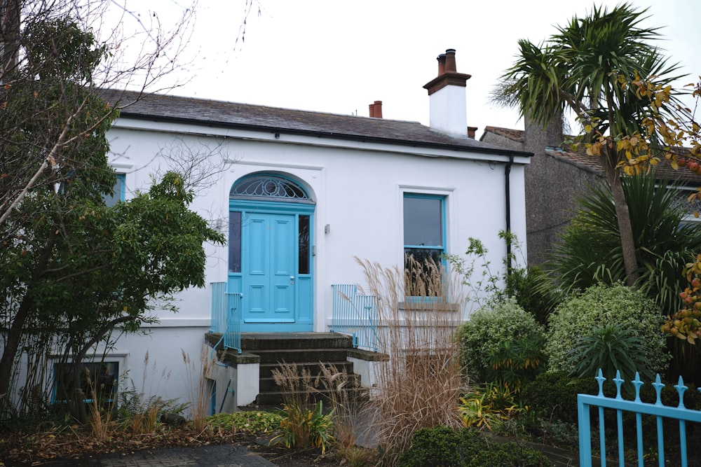 una casa blanca con una puerta de entrada azul