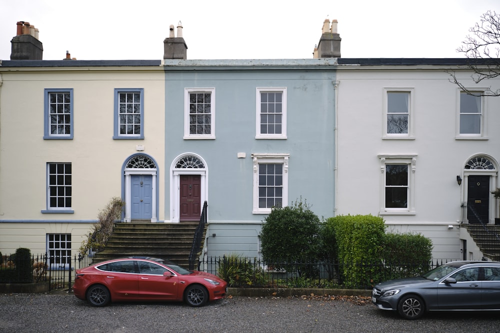 two cars parked in front of a row of houses