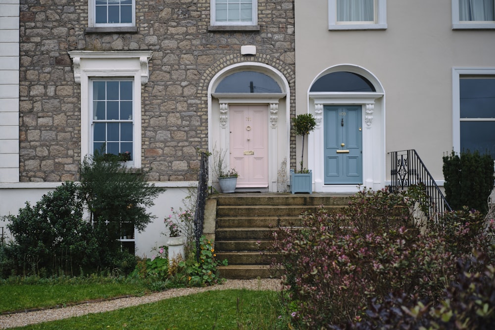 a house with a pink door and steps leading up to it