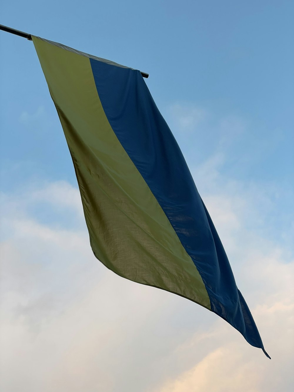 a blue and yellow flag flying in the sky