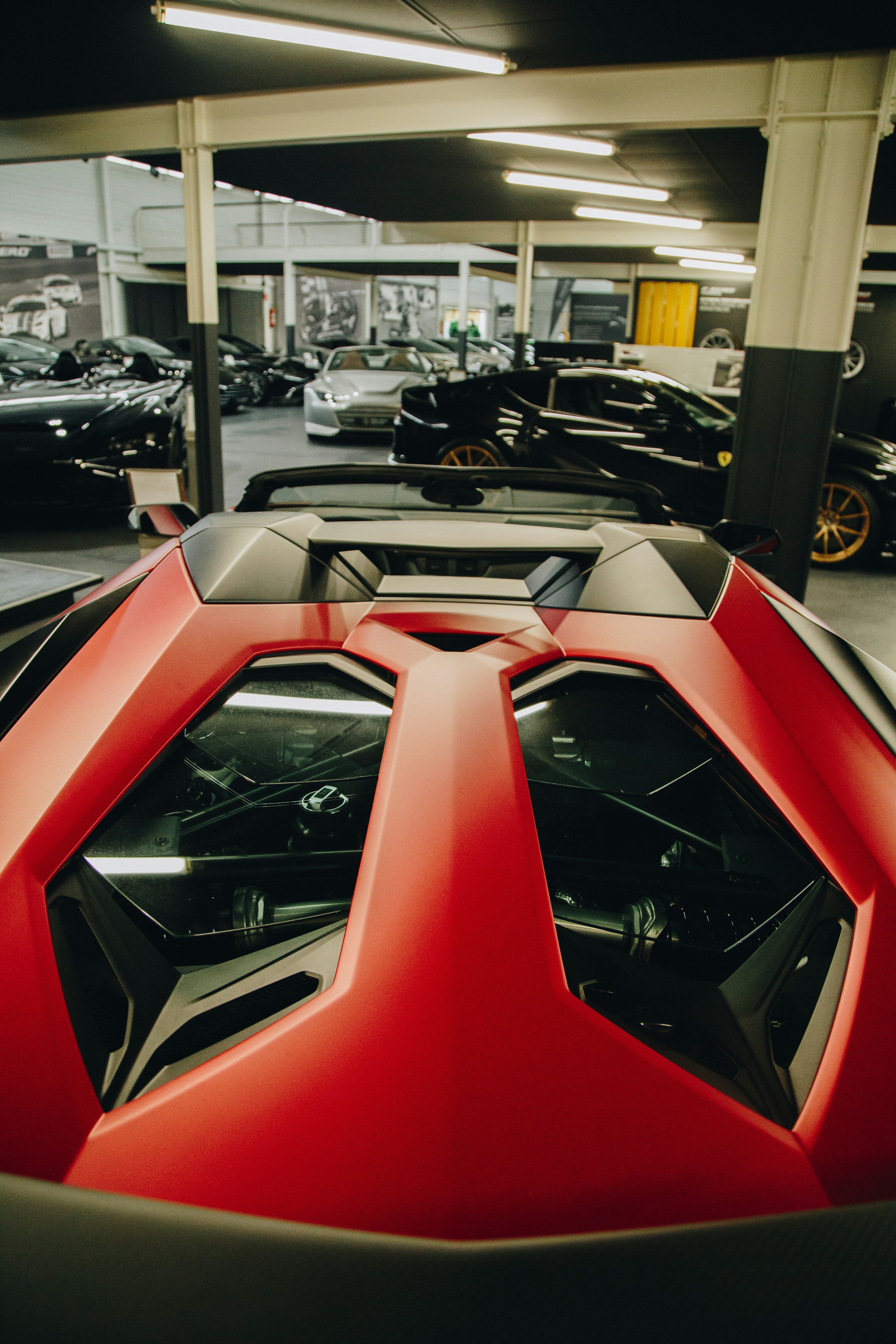 Ein rot-schwarzer Sportwagen, der in einer Garage geparkt ist