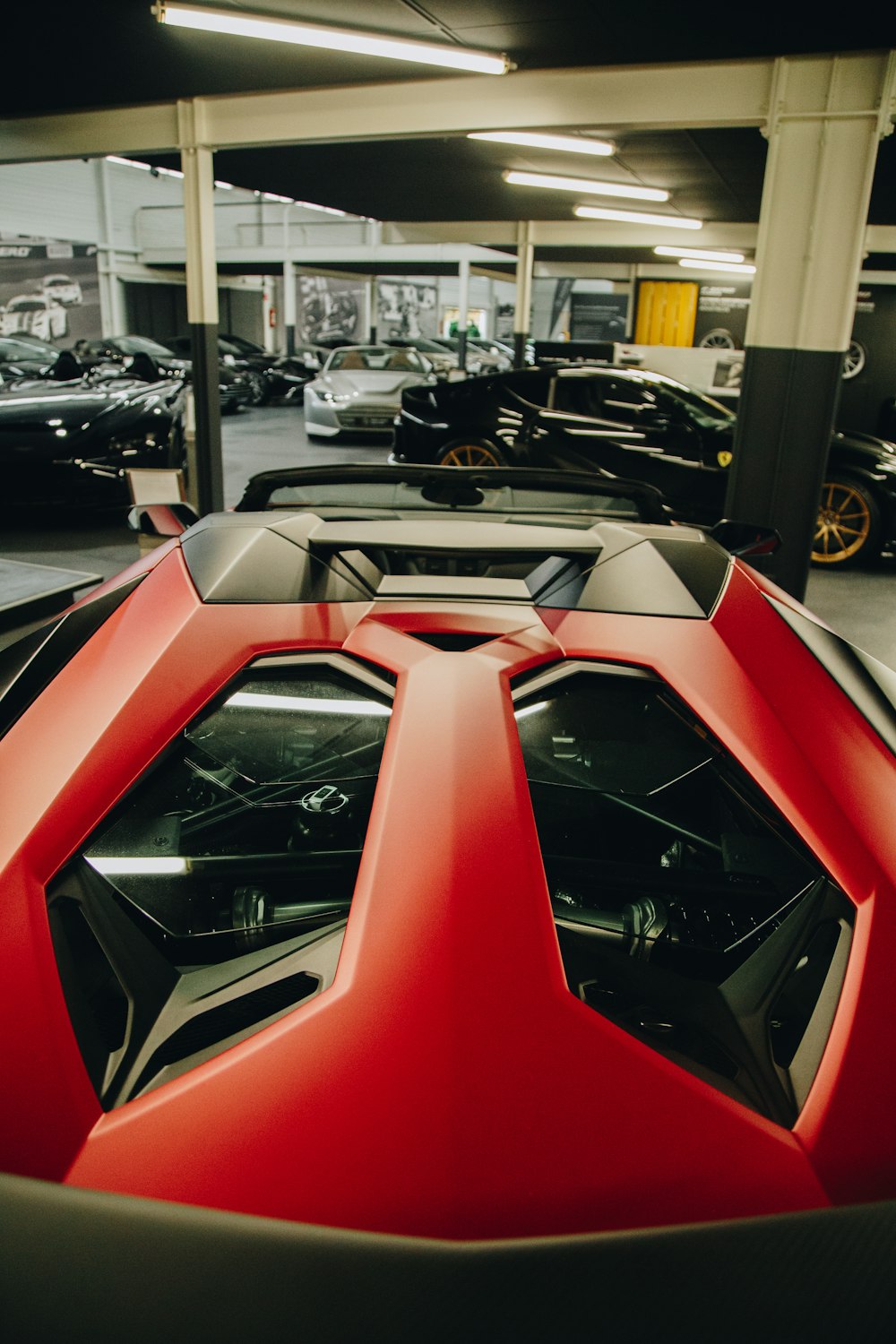 a red and black sports car parked in a garage