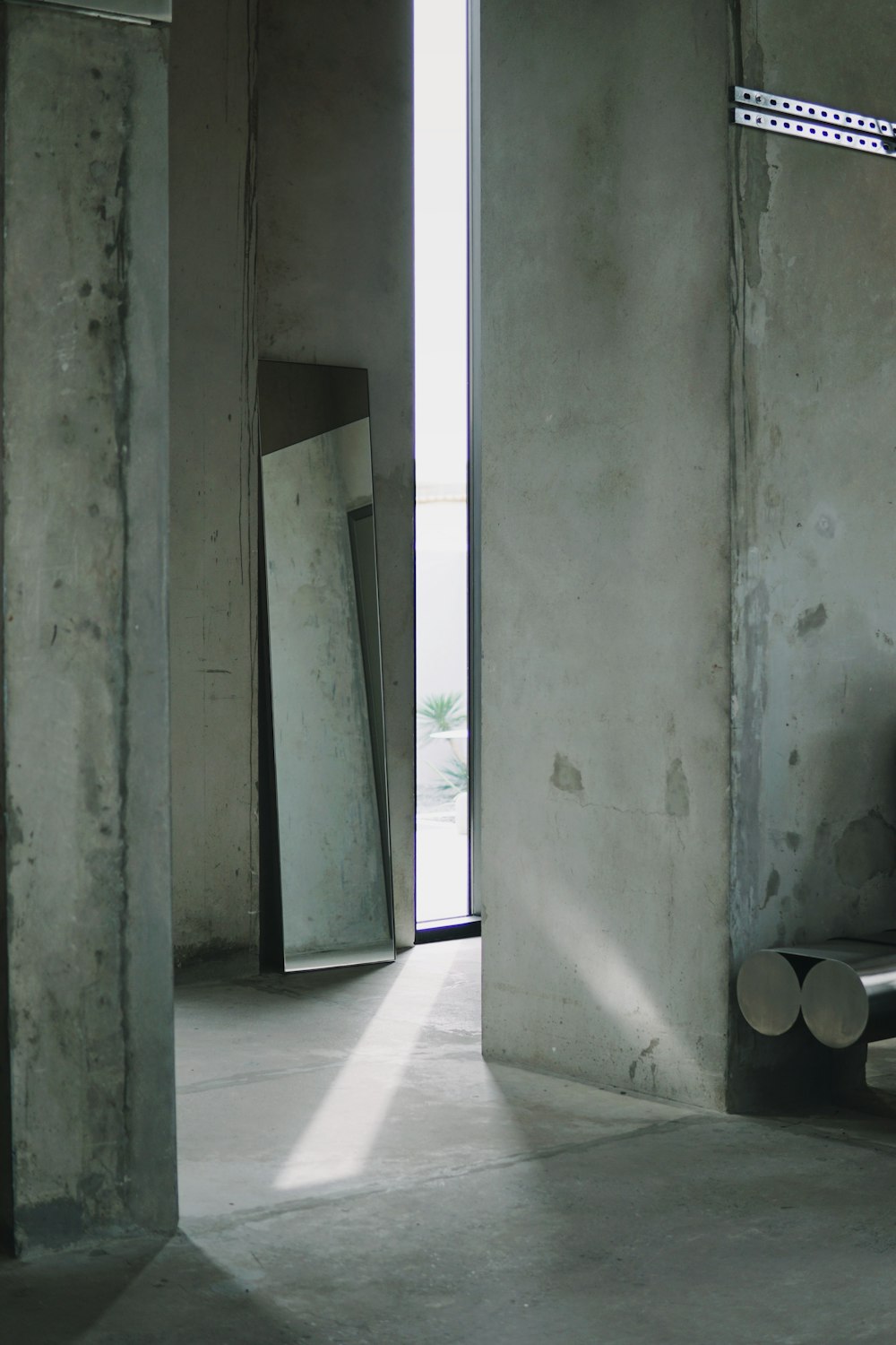 a room with concrete walls and a bench