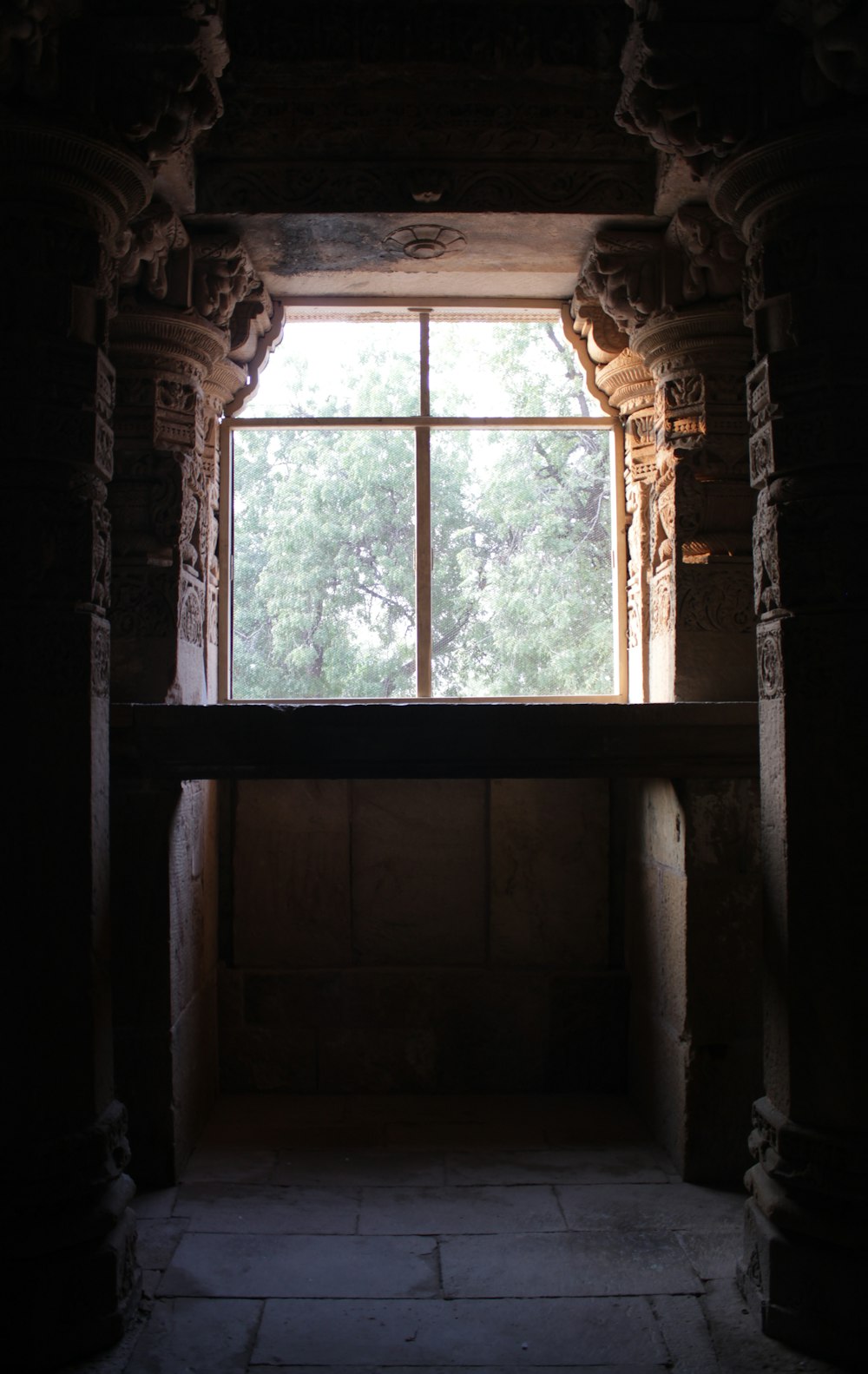 a dark room with a window and a stone floor