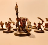 A group of intricately detailed fantasy miniatures with exaggerated features and expressive faces, arranged in a dynamic pose. The figures are painted with attention to detail, featuring sharp weapons and fierce expressions.