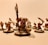 A group of intricately detailed fantasy miniatures with exaggerated features and expressive faces, arranged in a dynamic pose. The figures are painted with attention to detail, featuring sharp weapons and fierce expressions.