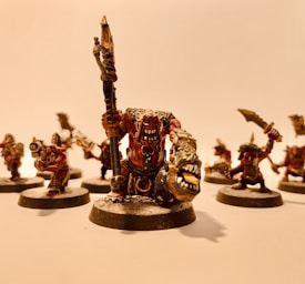 A group of intricately detailed fantasy miniatures with exaggerated features and expressive faces, arranged in a dynamic pose. The figures are painted with attention to detail, featuring sharp weapons and fierce expressions.