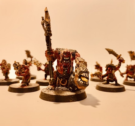 A group of intricately detailed fantasy miniatures with exaggerated features and expressive faces, arranged in a dynamic pose. The figures are painted with attention to detail, featuring sharp weapons and fierce expressions.