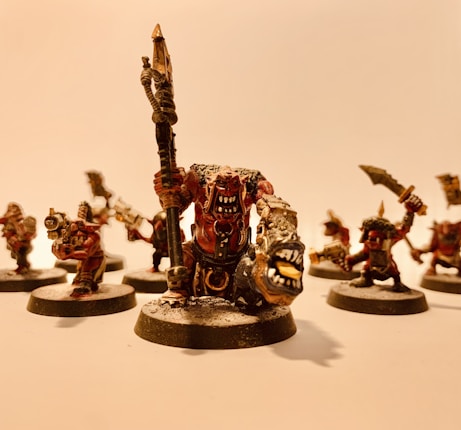 A group of intricately detailed fantasy miniatures with exaggerated features and expressive faces, arranged in a dynamic pose. The figures are painted with attention to detail, featuring sharp weapons and fierce expressions.