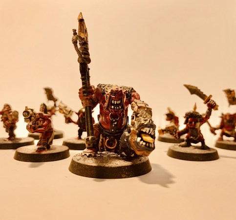 A group of intricately detailed fantasy miniatures with exaggerated features and expressive faces, arranged in a dynamic pose. The figures are painted with attention to detail, featuring sharp weapons and fierce expressions.