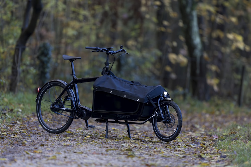 a bicycle with a bag on the back parked in the woods