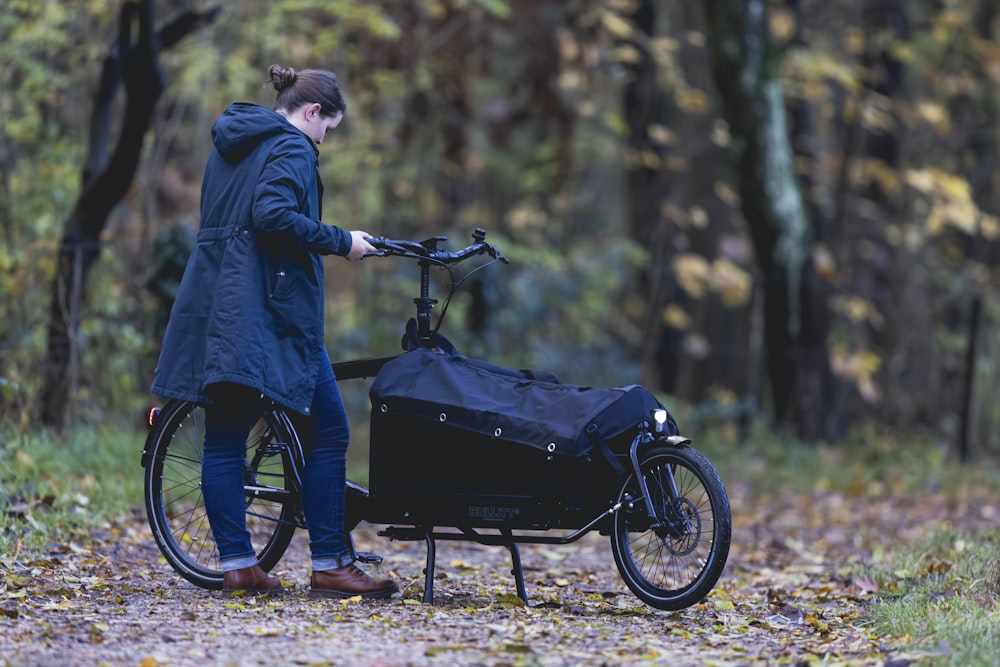 a person standing next to a bike in the woods