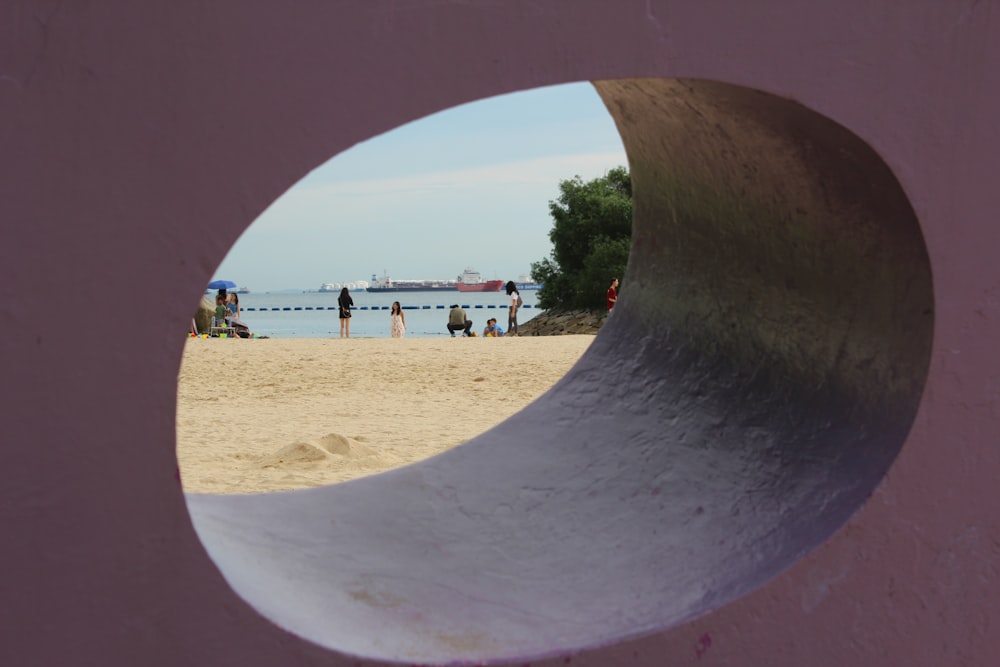 a view of a beach through a hole in a wall