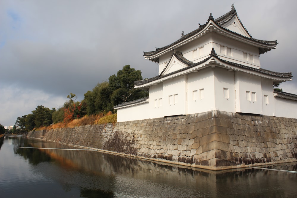 a white building sitting on the side of a river