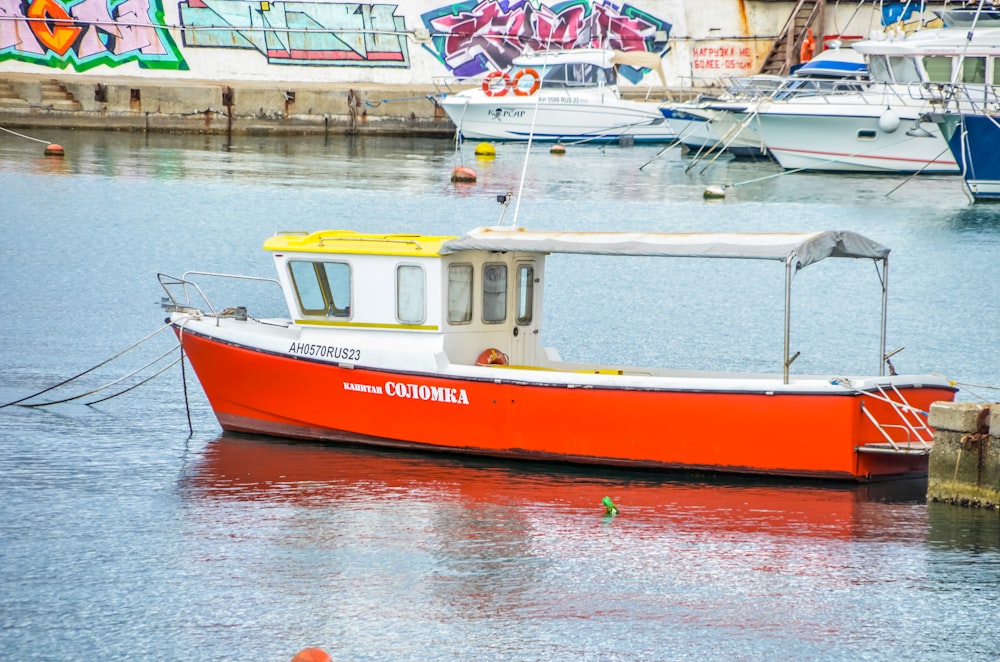 a red and white boat docked in a harbor