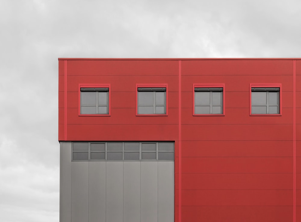 a red building with three windows on the side of it